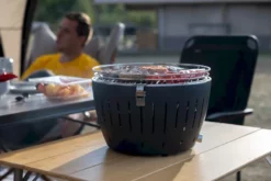 LotusGrill Classic Houtskoolbarbecue - Rood 18 LotusGrill Classic Houtskoolbarbecue - Rood -Intex VERKAUF lotusgrill in gebruik met toppy shirtje 3